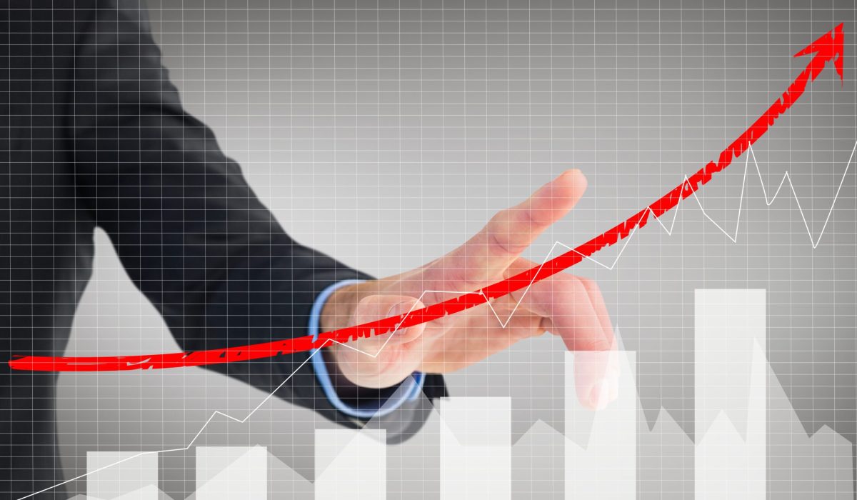 composite of businessman pointing at rising graph